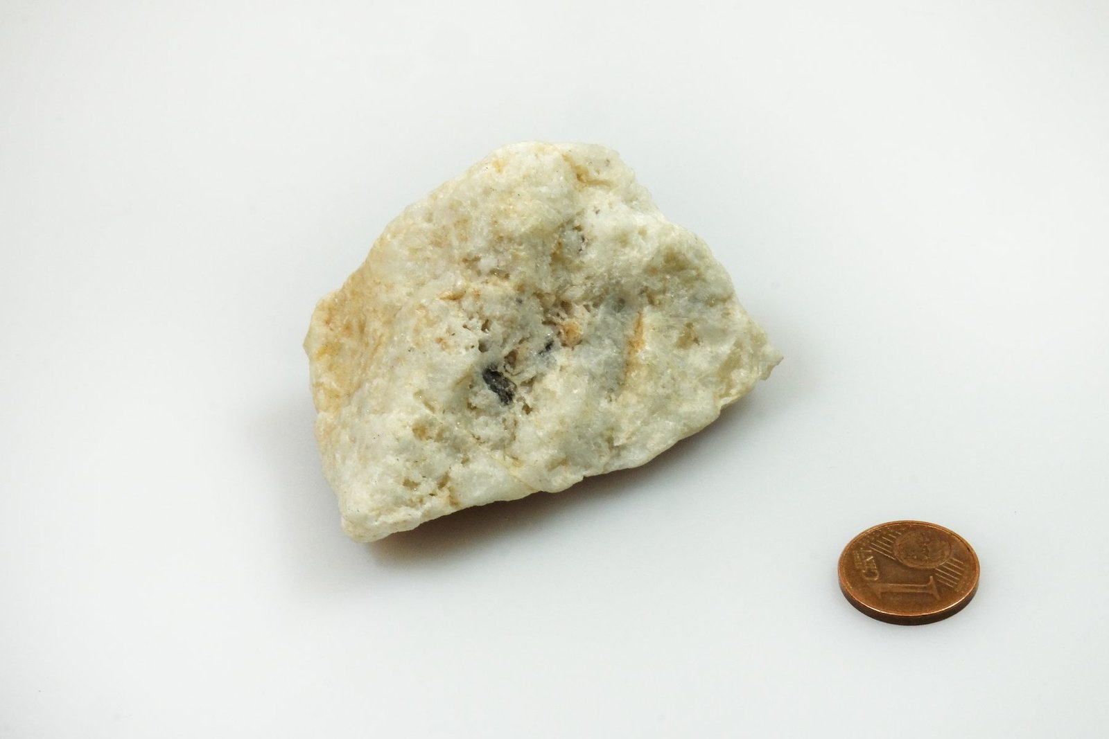 A specimen of lithium-bearing ore from Bikita, Masvingo Province: pale bikitaite, eucryptite and lepidolite, with a coin for scale