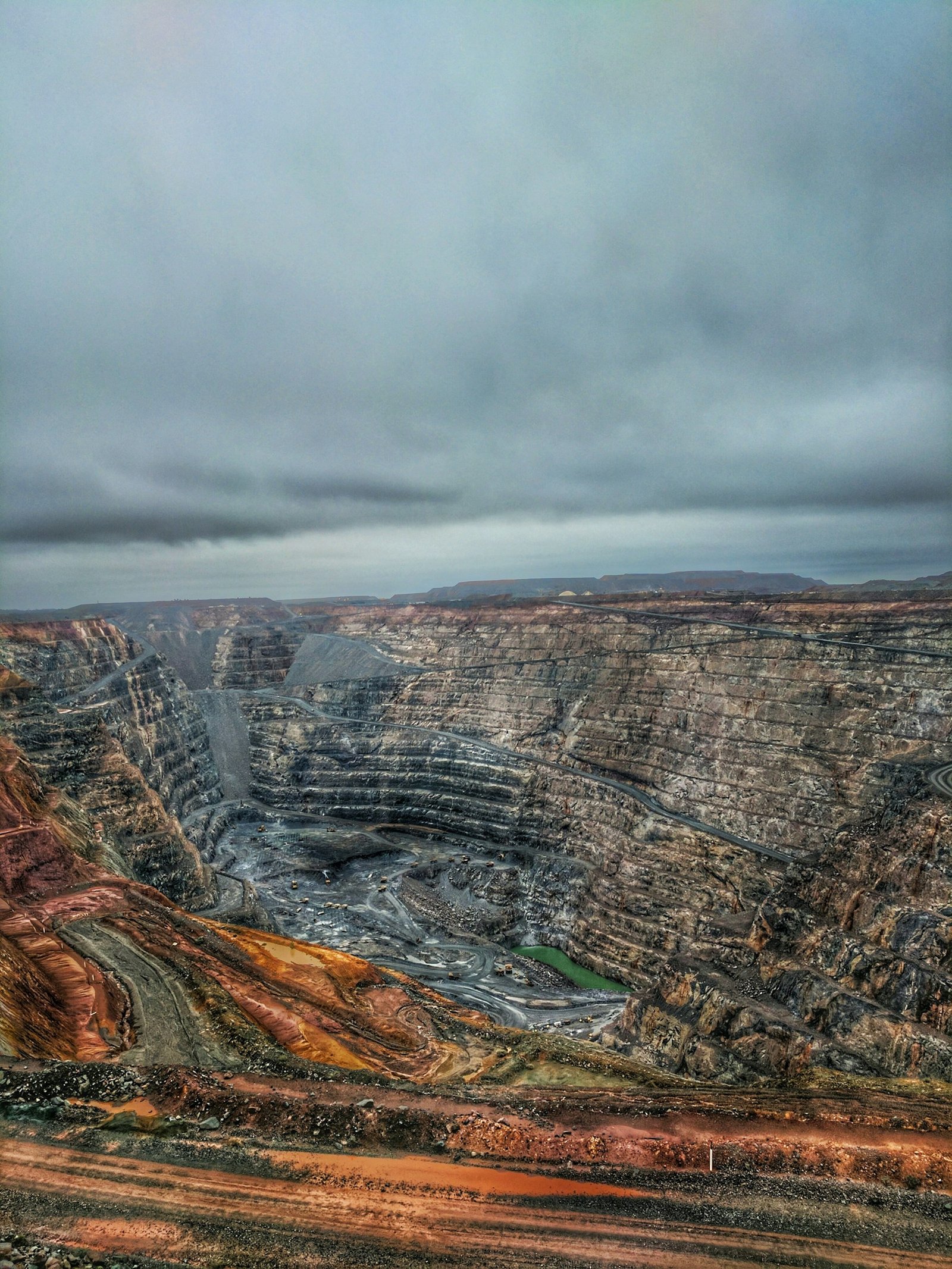 A large open-pit excavation cut in terraces into bare ground
