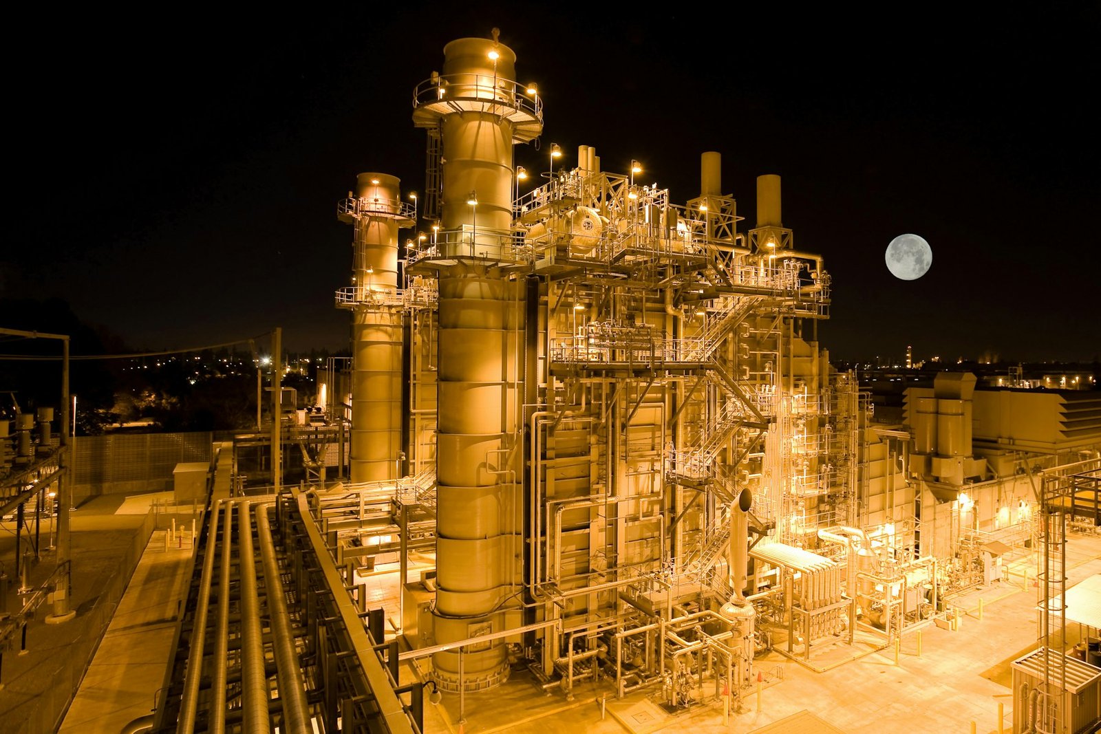 An industrial power plant lit up at night, its structures picked out against the dark