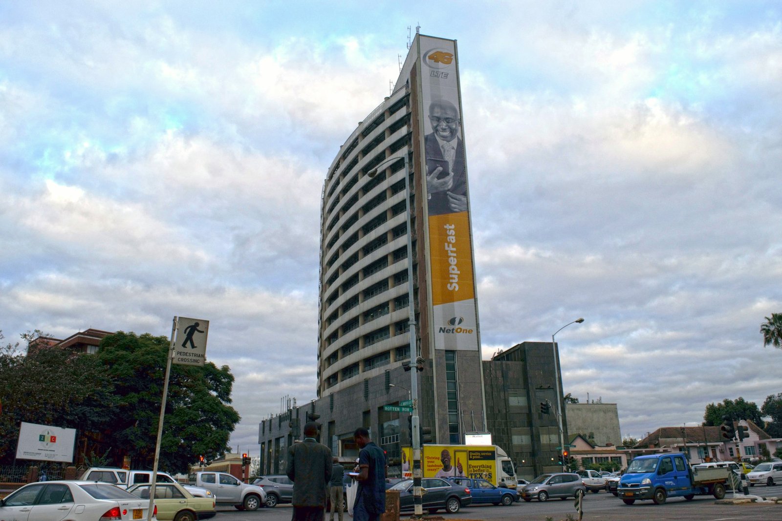 A tall office tower rising above an open parking lot