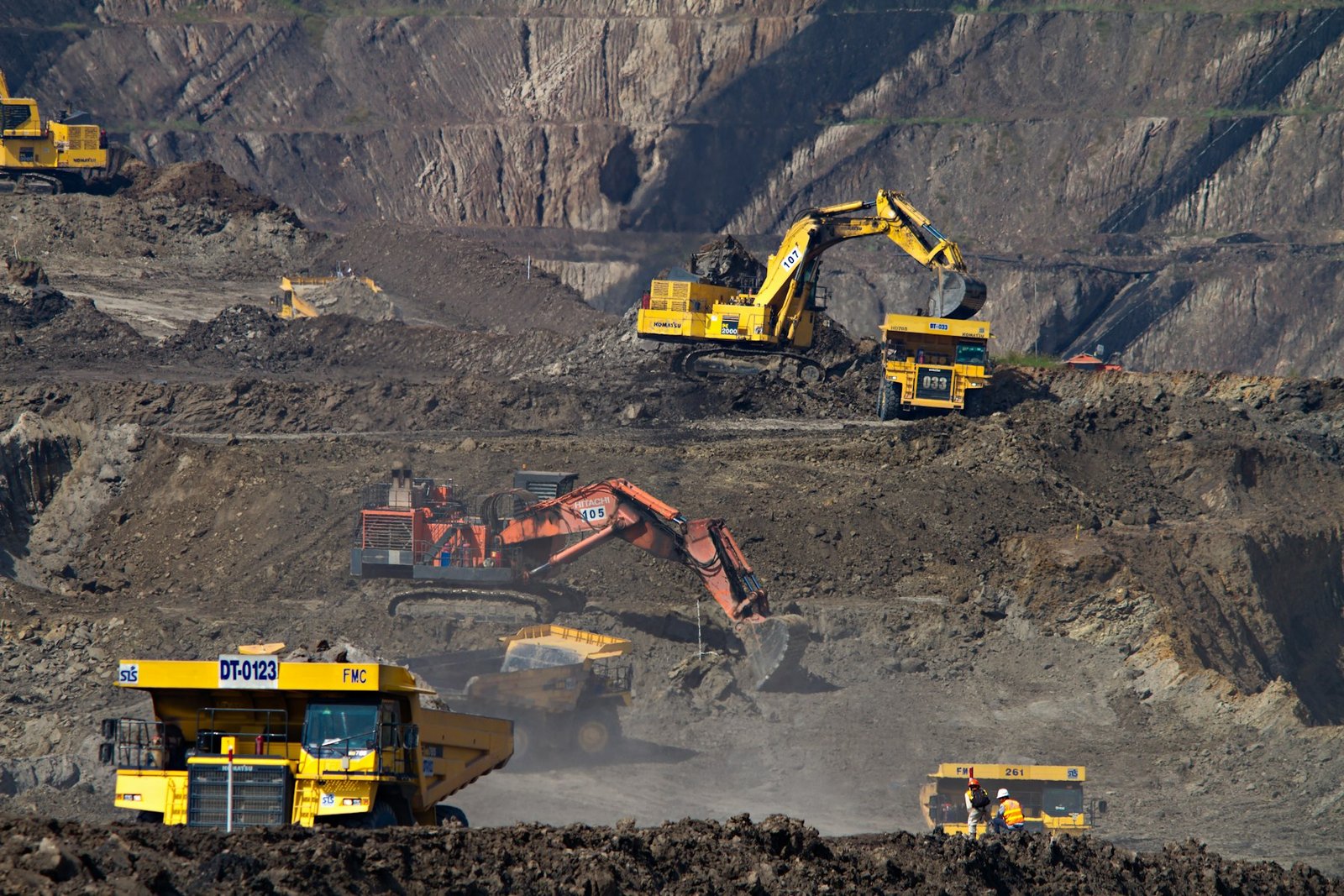 Open-pit mine benches worked by hydraulic excavators and haul trucks